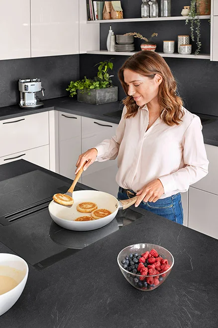 Kochen am Kochfeld mit integriertem Abzug – ergonomische Lösung für mehr Kopffreiheit.