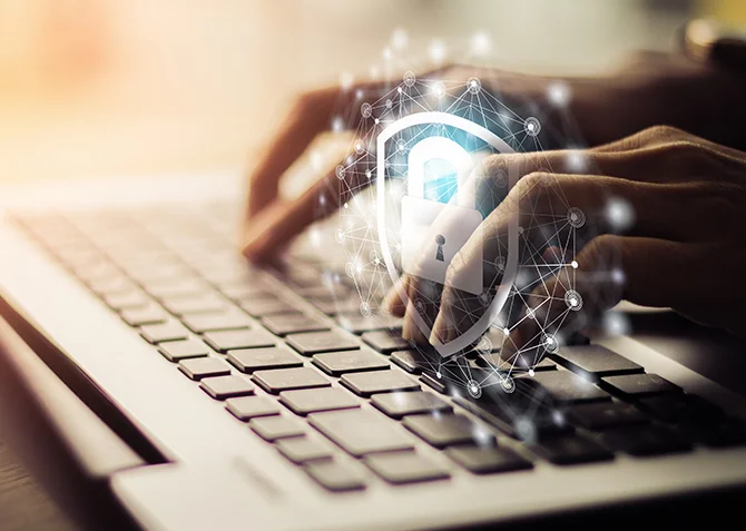 Hände, die auf einem Laptop tippen, mit einem digitalen Vorhängeschloss, das Cybersicherheit und Informationsschutz in einer Online-Umgebung symbolisiert.