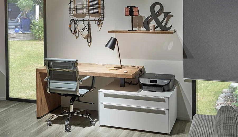 Modernes Homeoffice mit einem eleganten Holzschreibtisch, ergonomischem Stuhl, stilvoller Lampe und Drucker, ergänzt durch ein dekoratives Regal und einen ruhigen Blick ins Freie.