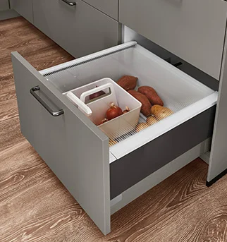 Moderne Küchenschublade, die eine organisierte Aufbewahrungslösung mit einem integrierten Fach für frisches Gemüse wie Süßkartoffeln und Zwiebeln zeigt.