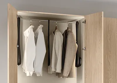 Kleiderschrank im Schlafzimmer mit Kleiderlift und hängenden Hemden, Pullovern und Jacken aus Holz