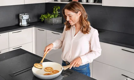 Kochen am Kochfeld mit integriertem Abzug – ergonomische Lösung für mehr Kopffreiheit.