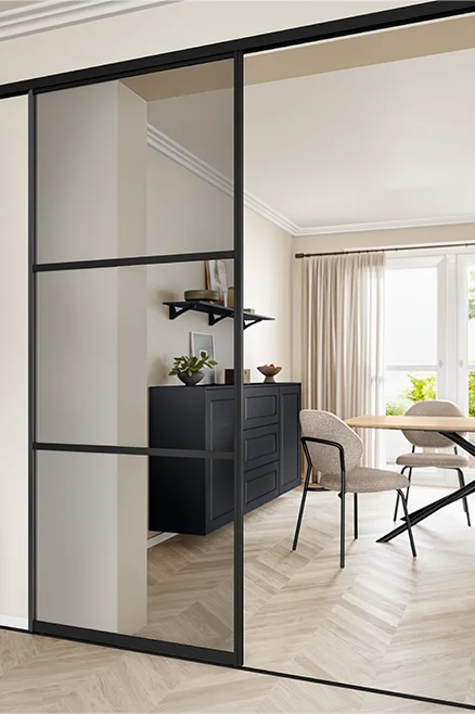 Vorwandgleittür mit Grauglas - moderne Raumlösung mit schwarzem Rahmen, Blick ins offene Esszimmer.