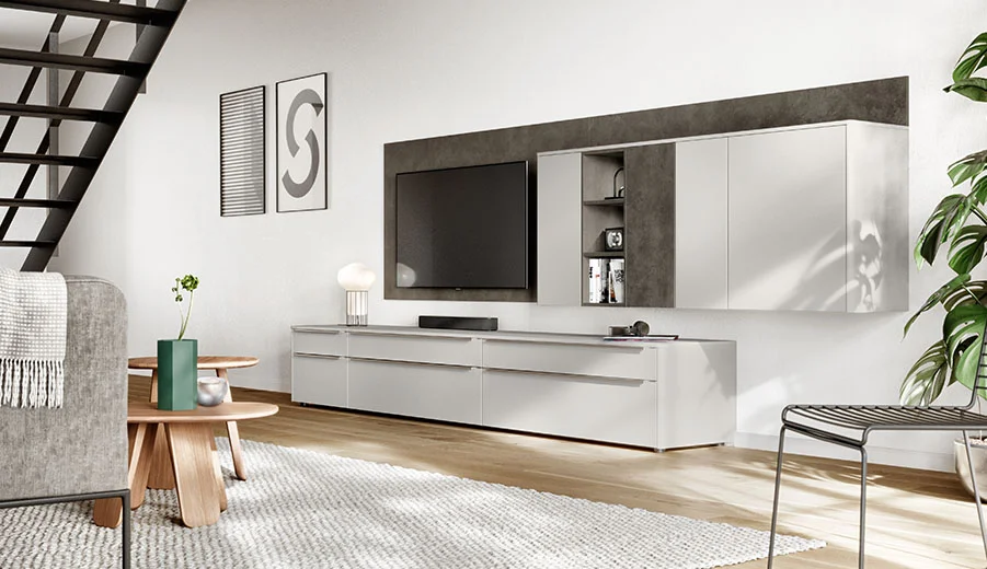 Zeitgemäßes Wohnzimmer mit schlanker, wandmontierter TV-Anlage, minimalistischen Möbeln und einer neutralen Farbpalette, die modernes Design und Komfort widerspiegelt.