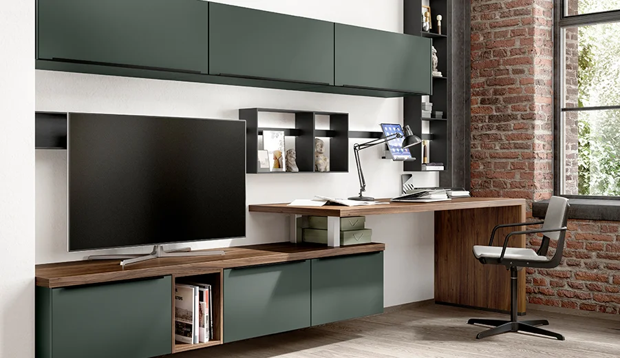 Modernes Homeoffice mit eleganten Möbeln, darunter ein wandmontierter Schreibtisch, Regale, dunkelgrüne Schränke und ein bequemer Stuhl, akzentuiert durch eine Ziegelwand im Hintergrund.