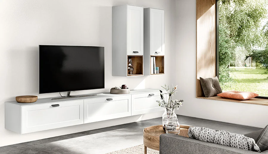 Modernes Wohnzimmerinterieur mit elegantem weißen Unterhaltungseinheit, wandmontierten Schränken und einem großen Fenster mit Blick auf saftiges Grün.