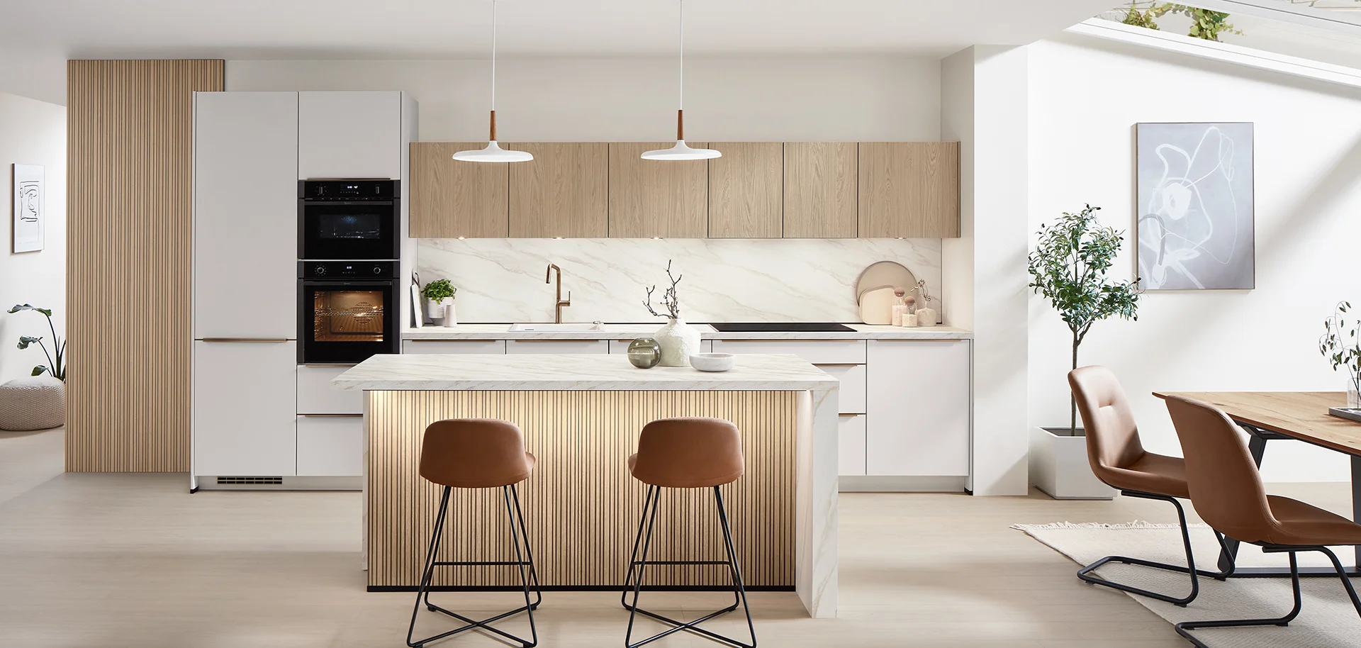 Moderne, helle Küche mit Holzdetails, einer großen Insel und stilvollen Barhockern.
