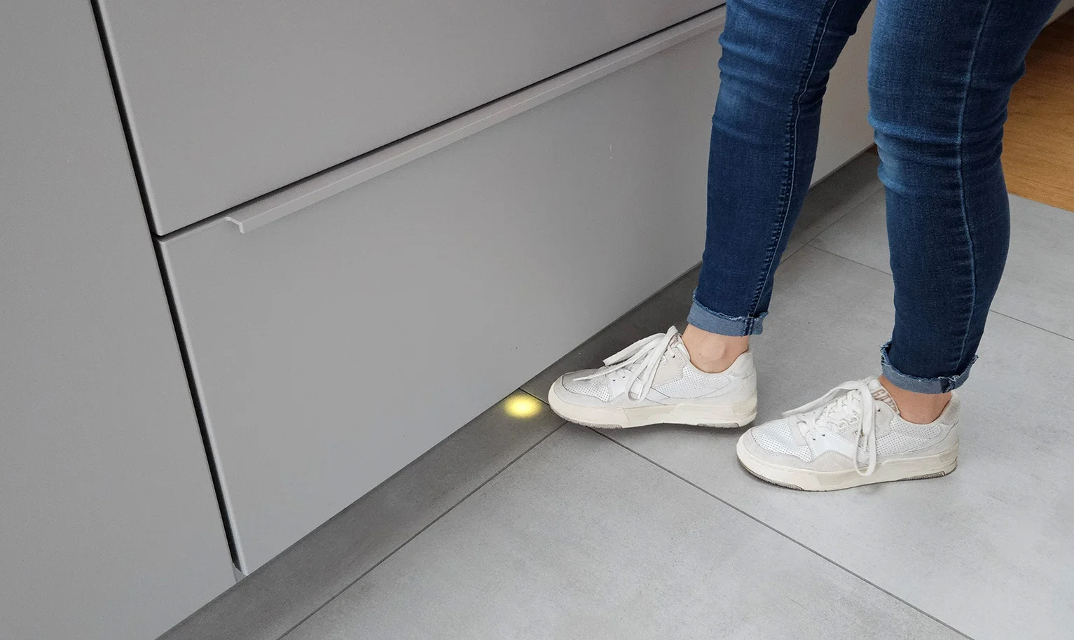 Küche mit Mülltrennung per Fußbedienung – Fuß aktiviert Sensor und öffnet komfortabel den Frontauszug.
