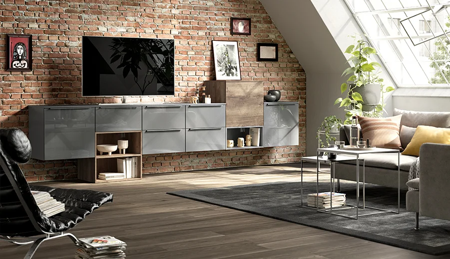 Modernes Wohnzimmerinterieur mit einem eleganten wandmontierten TV-Schrank, einer freiliegenden Ziegelwand, gemütlichem Sofa und einem Oberlicht, das eine warme und stilvolle Atmosphäre hervorruft.